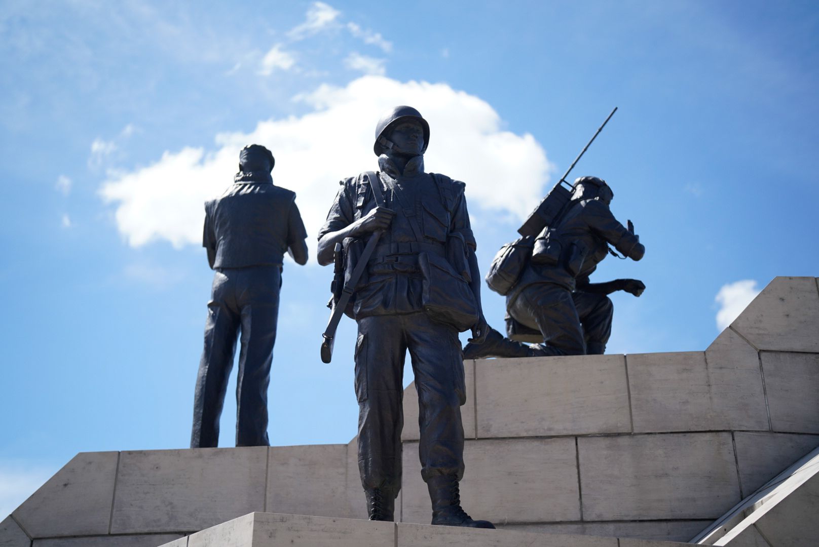 Statues - three uniformed figures in alert.