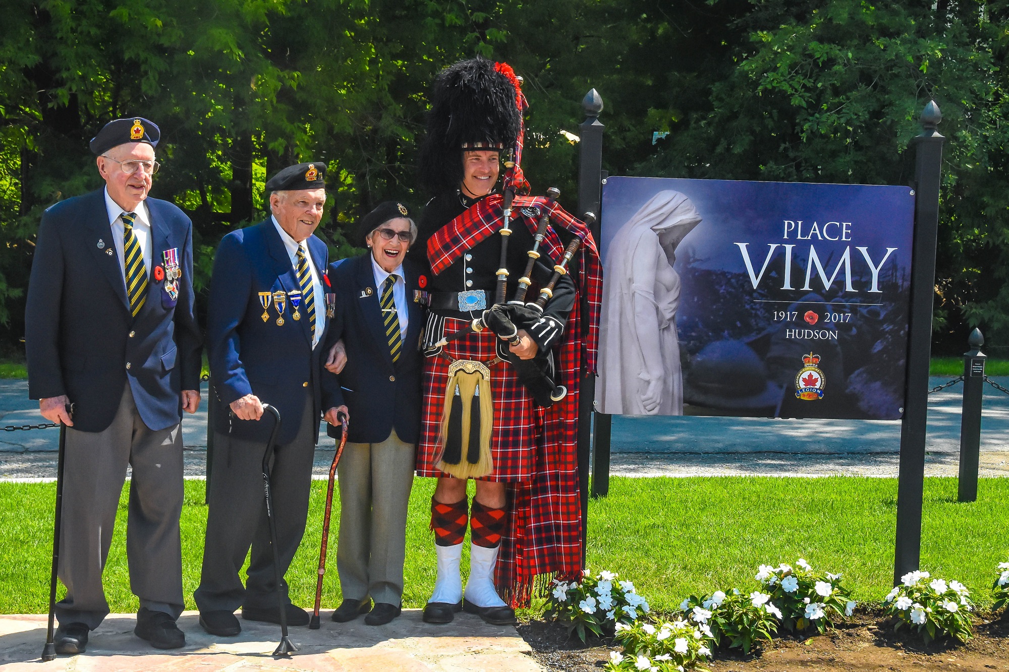 Second World War Veterans Norm St. Aubin, Peter Stephenson, Maxine Bredt and piper Graham Batty at Place Vimy sign