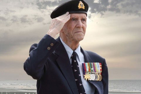 D-Day Veteran Harold Tilley in beret and wearing multiple medals, saluting on Juno Beach.