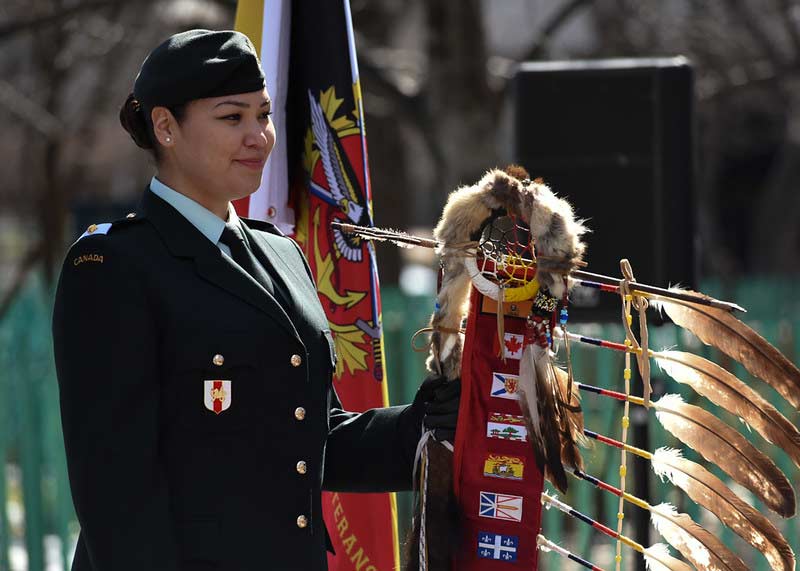 A member of the Canadian Armed Forces holds the Eagle Staff during a ceremony on Indigenous Veterans Day, November 8, 2017. Photo: VAC 