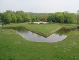 Man made small island in the shape of a maple leaf, maple trees in the background.